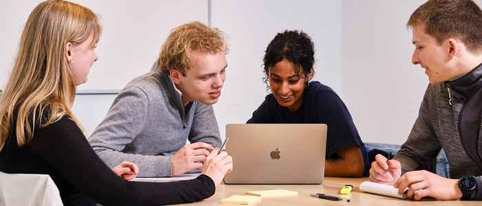 Students looking at a laptop studying