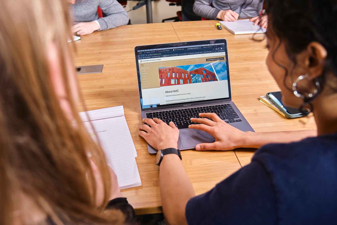 AUC students sitting at a laptop typing