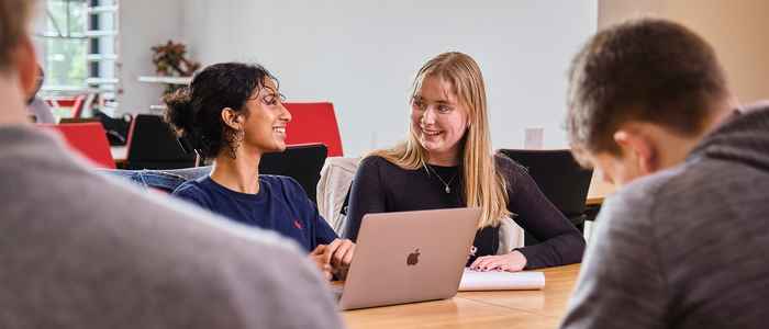 Students looking at a laptop studying