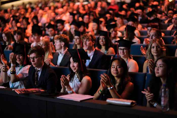 Crowd at Graduation Ceremony, faces looking forward toward stage