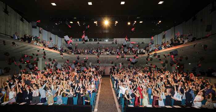 Photo showing hats thrown in the air as conclusion of graduation