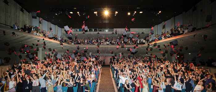 Graduation hats thrown in the air in celebration of three years at AUC
