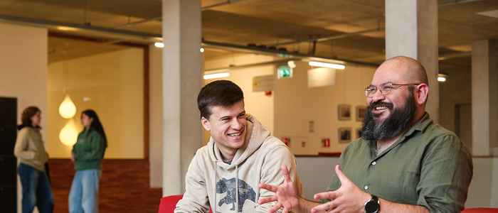Lecturer and student laughing and discussing in the AUC building