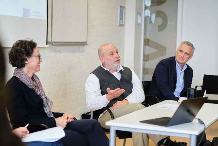 Three presenters behind a desk