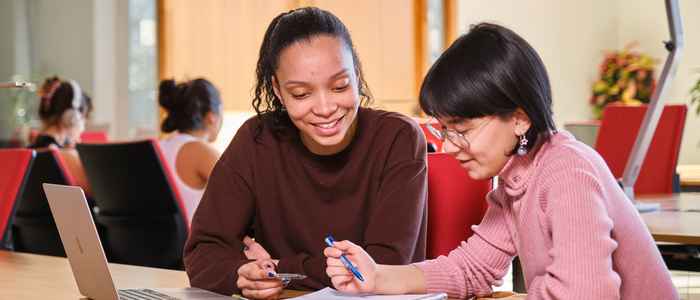 Students seated and facing the camera on the stairs at AUC