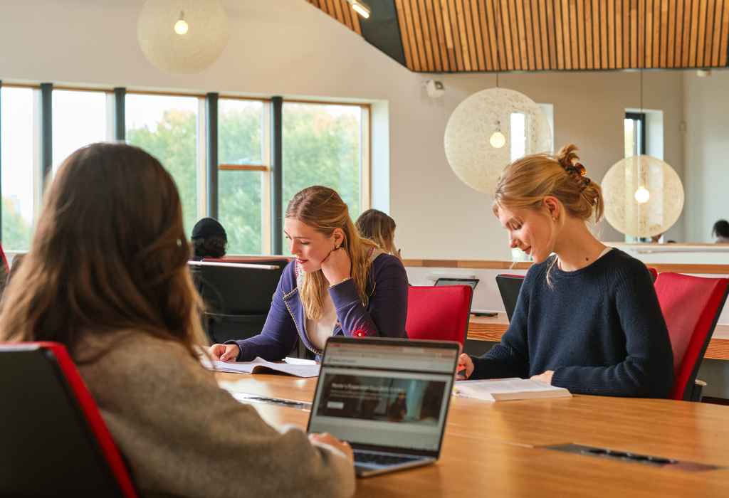 Two students at a desk filling in their applications